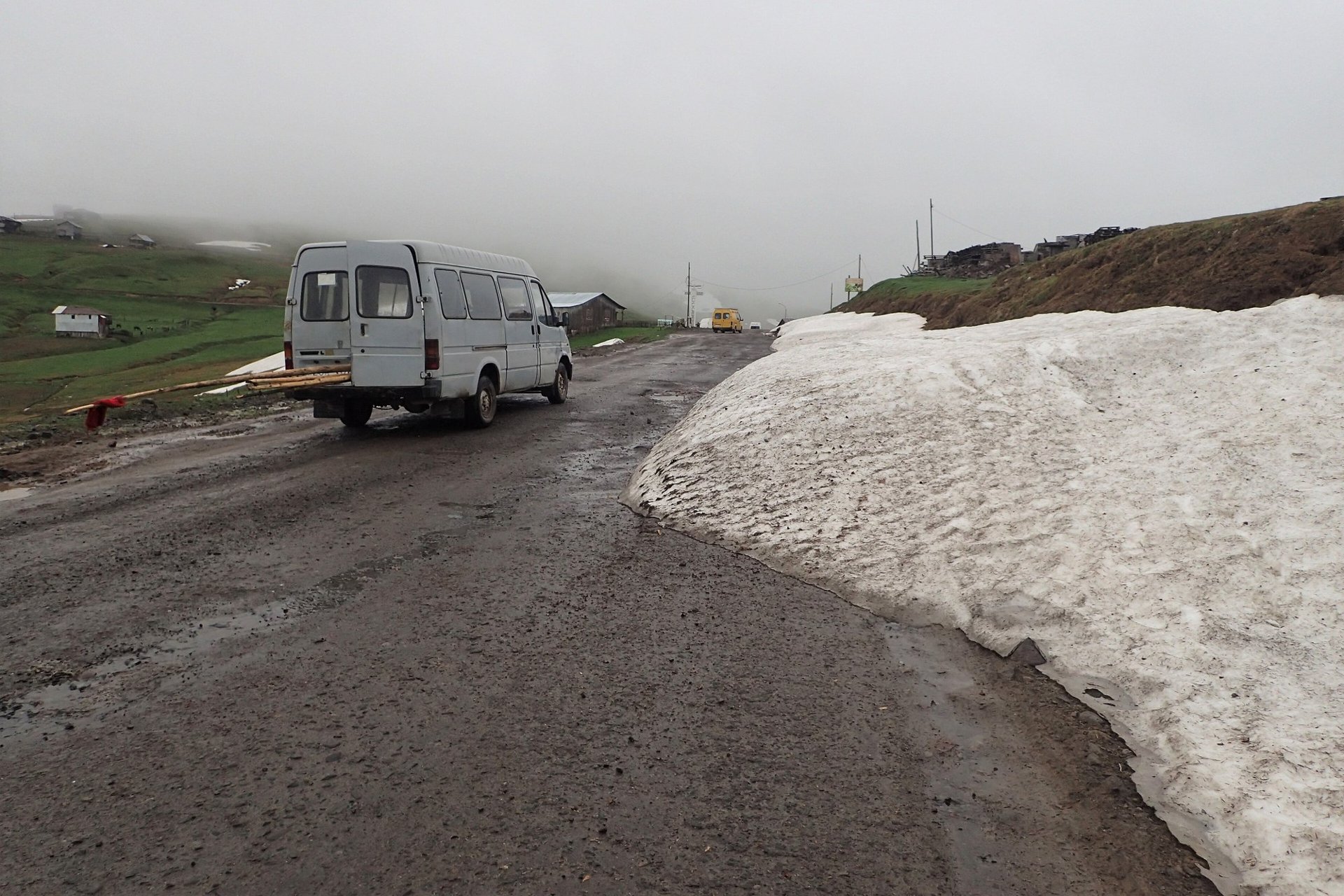 Road on the Goderdzi Pass with snow along the roadside and fog, May 2016