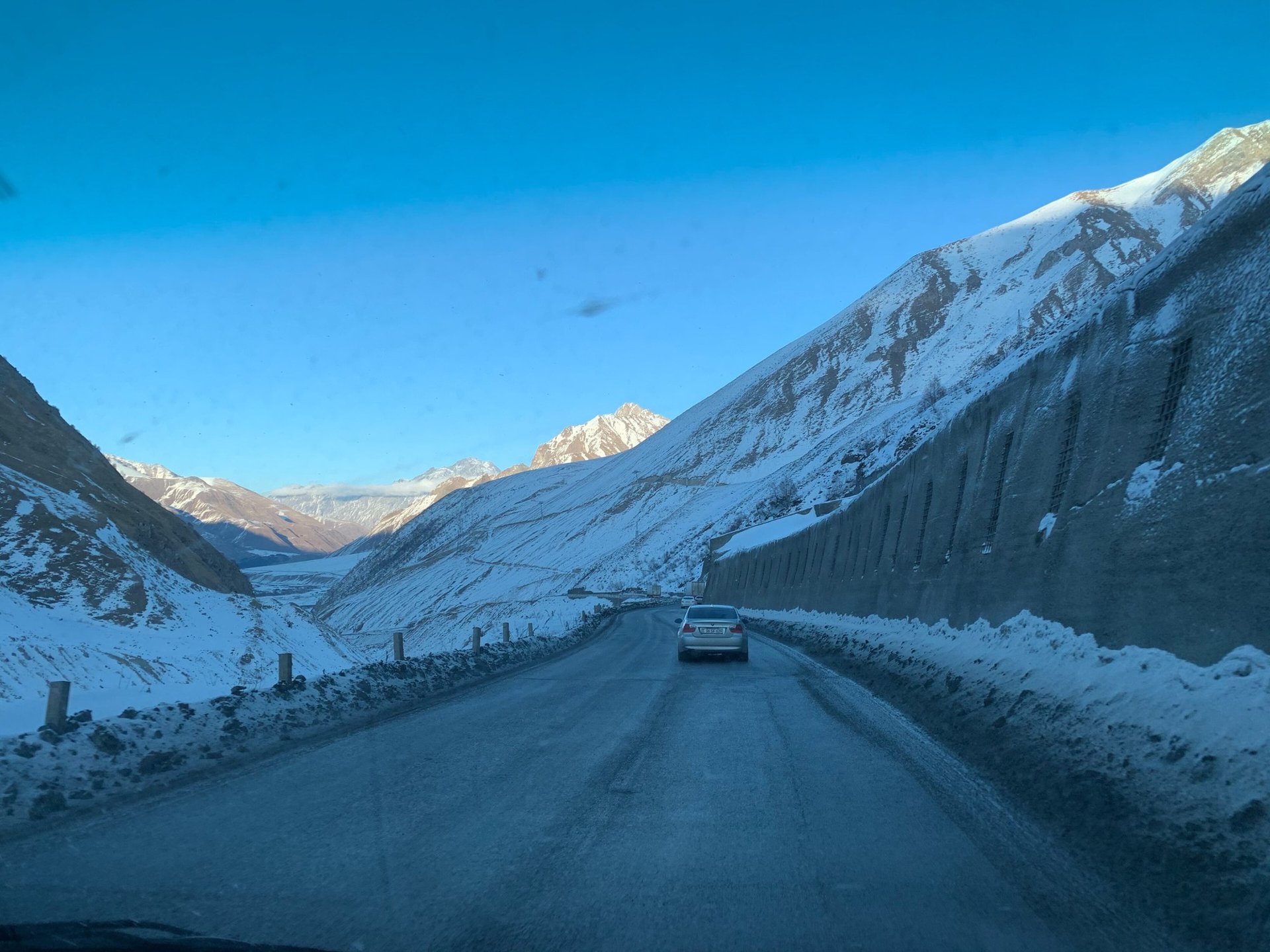 A car on an icy road next to an avalanche gallery on the Georgian Military Road, January 2020