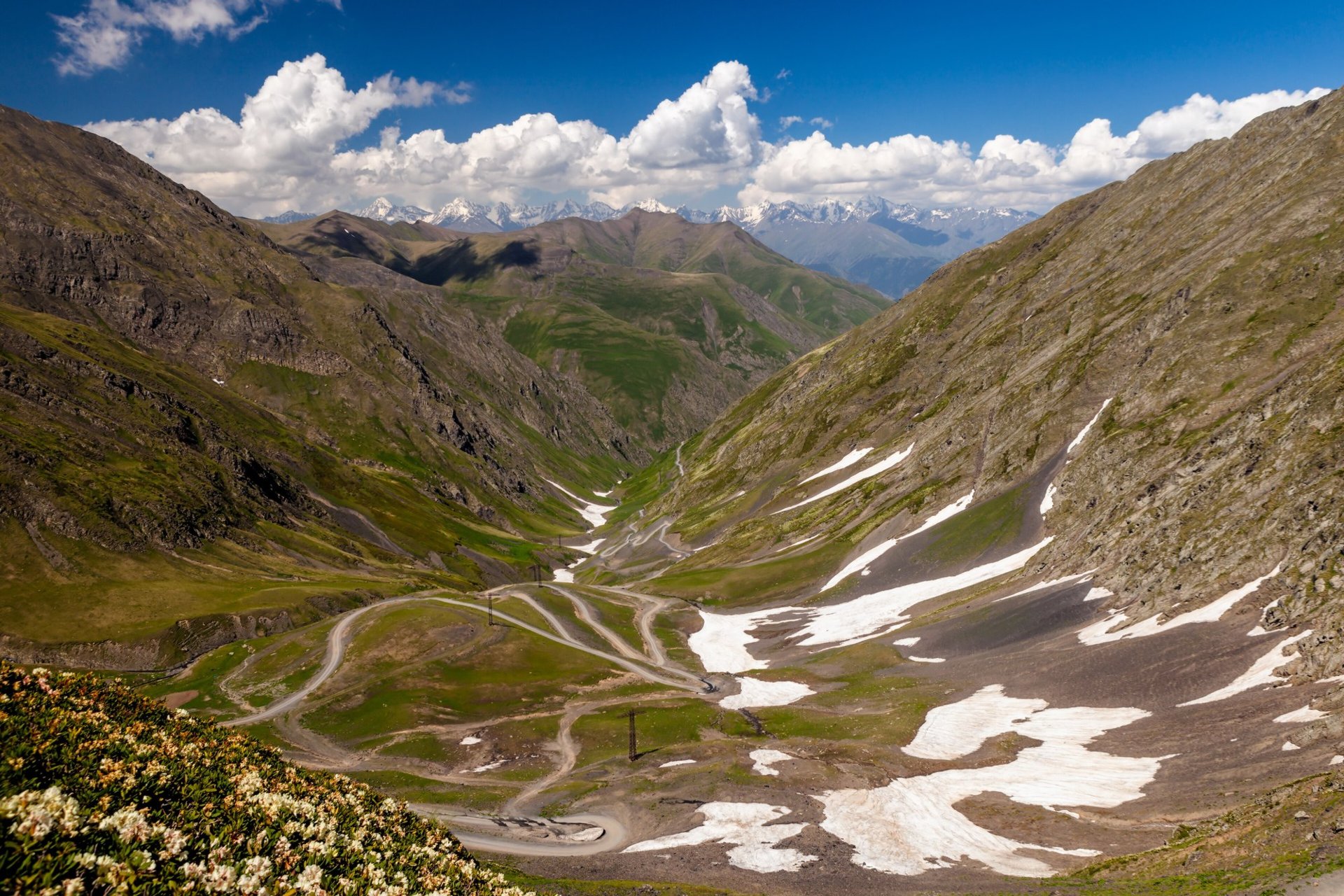 Switchbacks of the Tusheti road seen from the Abano Pass, patches of snow on the slopes, June